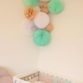 Chambre de bébé décorée d’une grappe de lampions vert et beige
