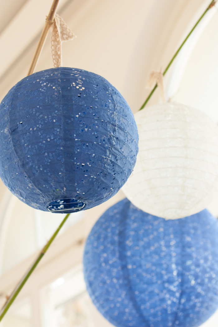 Un décor de noël scandinave bleu et argenté avec des lanternes dentelle et chinoise