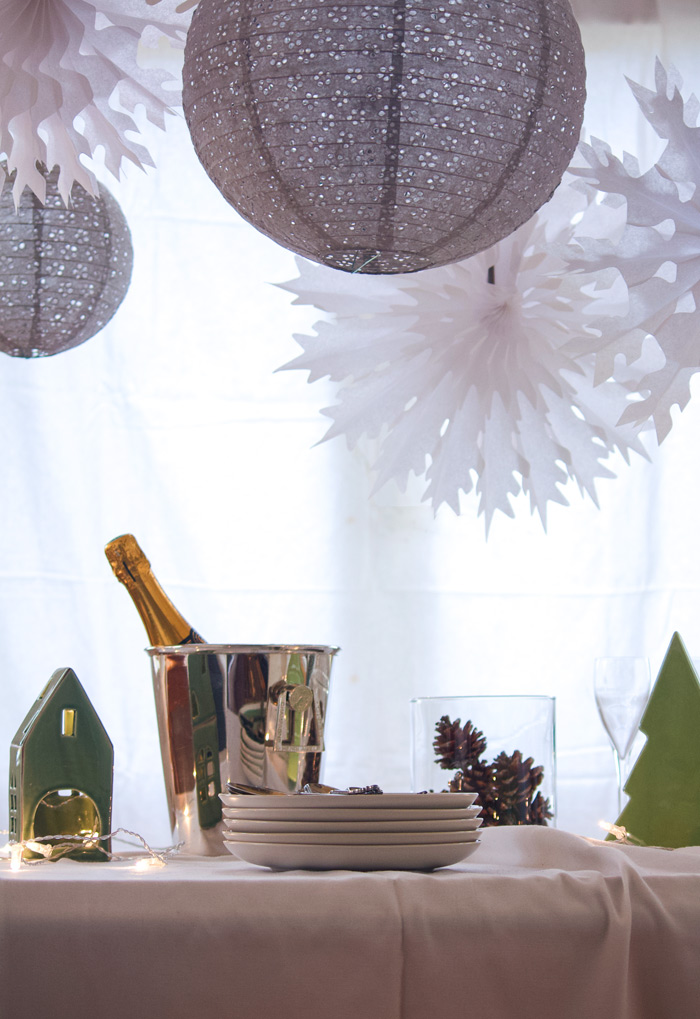 Un buffet de Noël blanc et gris avec des lanternes dentelle et des flocons